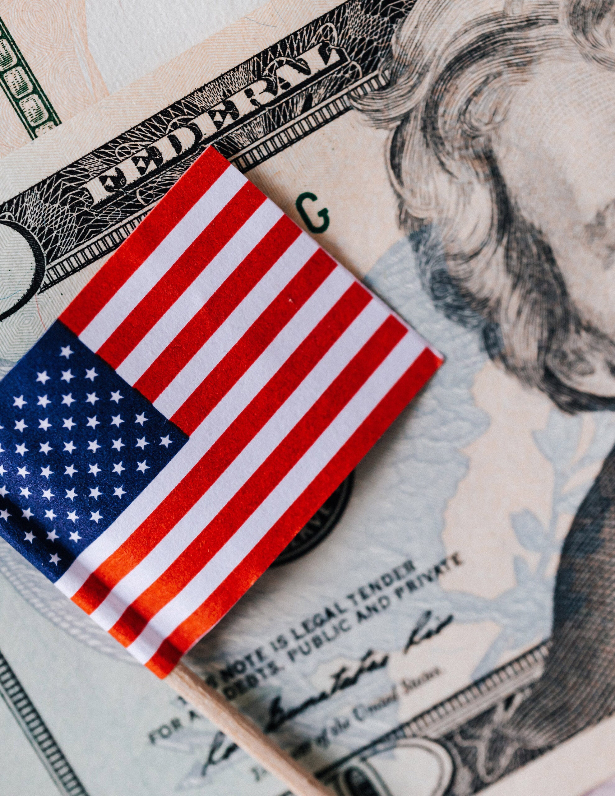 A pile of U.S. currency with a small U.S. flag